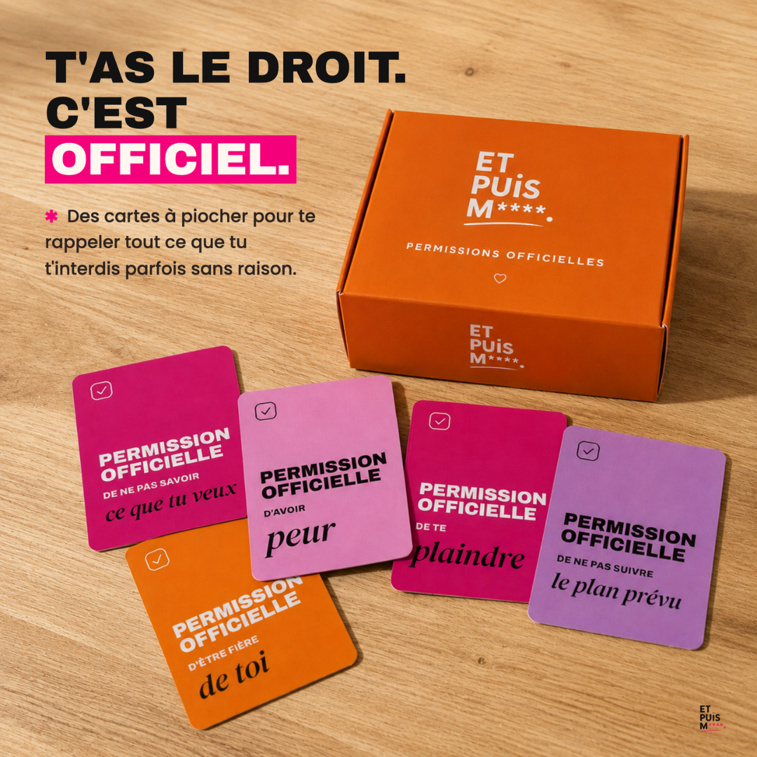 Coffret orange Permissions officielles et cartes colorées posées sur une table en bois